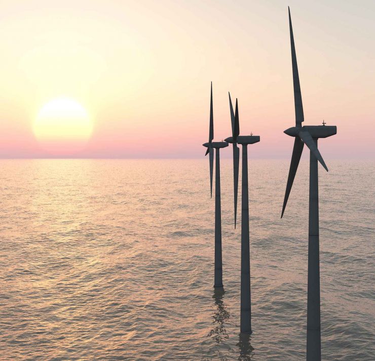windmills in the ocean at sunset